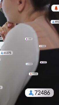 Vertical video: Streaming host holding chin, watching follower badges popping up, tracking growth