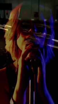 Vertical video: Singer lifting wrist toward mic, singing in studio and activating amberblue streaks