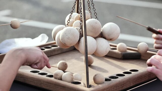 Children playing strategy board game, having fun and using wooden balls