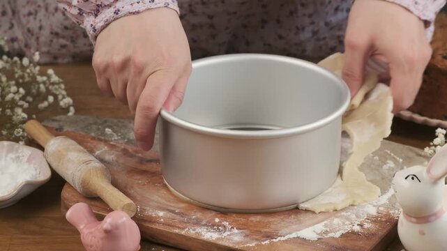 A woman cuts a circle of marzipan on a board to decorate a cupcake or cake. Step-by-step video recipes. Horizontal video.