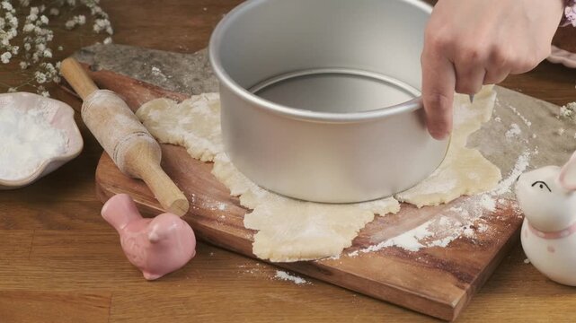 A woman cuts a circle of marzipan on a board to decorate a cupcake or cake. Step-by-step video recipes. Horizontal video.