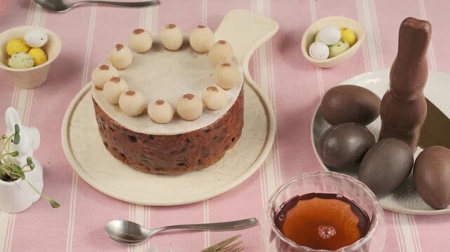 

Festive table setting with British Easter Simnel cake, decorated with marzipan balls, on a pink tablecloth. Step-by-step video recipes. Horizontal video. Happy Easter. 