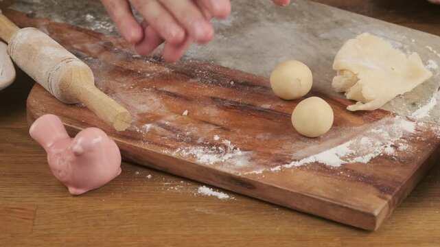 A woman rolls marzipan balls on a board to decorate a cupcake, cake, or make marzipan candies. Step-by-step video recipes. Horizontal video.
