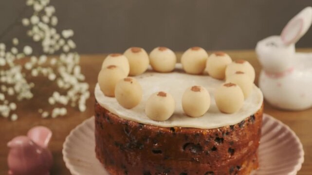 British Easter Simnel cake decorated with marzipan balls on a wooden table. Step-by-step video recipes. Horizontal video. Happy Easter