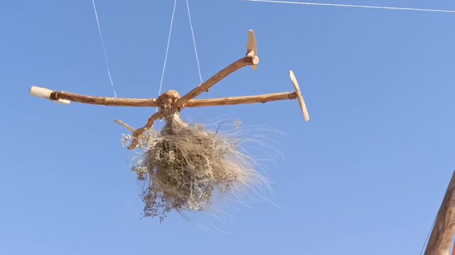 Decorative wooden wind spinner with dried flowers against blue sky