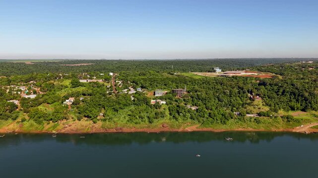 Aerial Panoramic View of Presidente Franco Paraguay Riverbank Town Along Parana River With Lush Tropical Green Vegetation