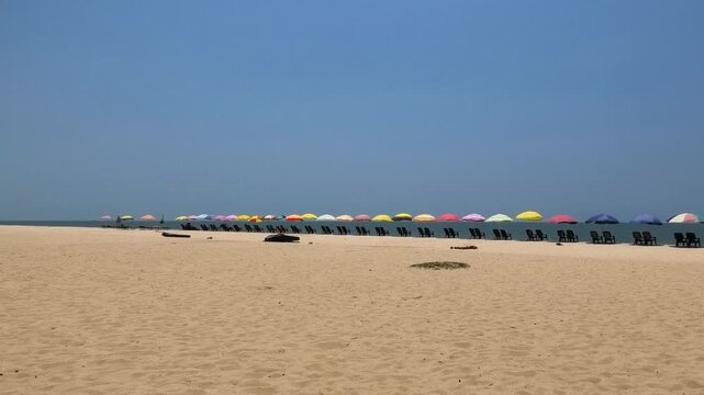 The beach with colorful umbrellas and chairs installed for tourists | Marari Beach, Alappuzha, Kerala, India