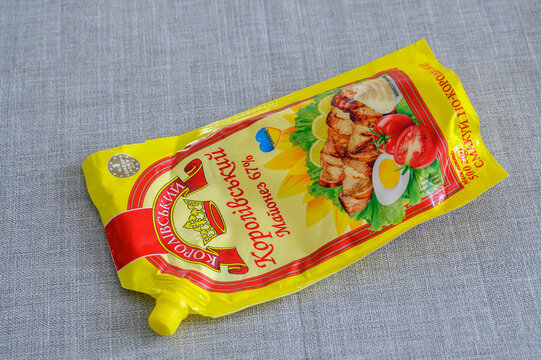 ISERLOHN, GERMANY &mdash; APRIL 11 2026: view of a yellow plastic pack of Korolivskyi Smak mayonnaise 67 percent on a grey textured surface.