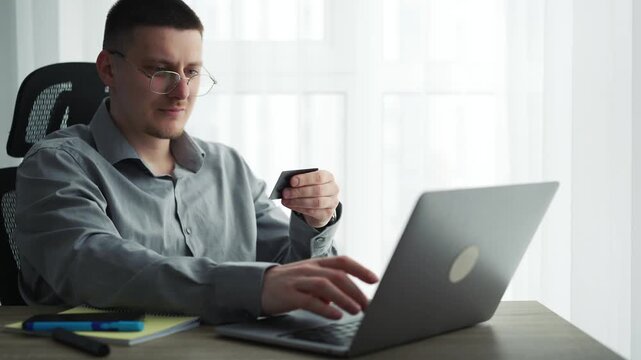 Businessman using a credit card and laptop for online payment in the office.
Online money transfer to a bank account.
Entering a card PIN to log in to your bank account.