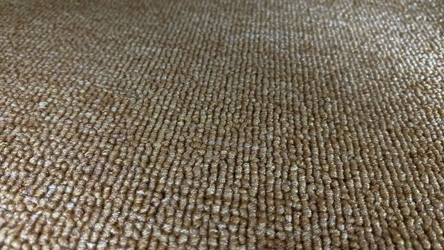 A close-up of a brown carpet texture with a dense, detailed grain pattern. This warm, natural look is perfect as a backdrop for modern interiors, decor, and design concepts.