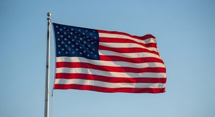 Obraz premium Honoring heroes a patriotic american flag waving against a clear blue sky on memorial day