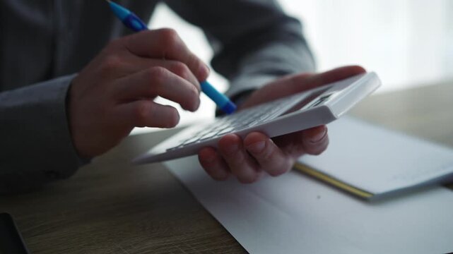Financial audit.
A bank employee counting money: a close-up of hands rapidly pressing calculator buttons to calculate and count