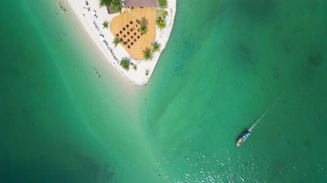 Koh Muk, Thailand: Aerial overhead drone footage of a sailboat sailing around the famous triangle shape beach in Koh Mook in the Andaman sea in Trang province in southern Thailand. 