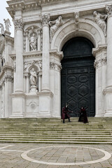 Obraz premium Venice, Italy - February 16, 2026 - People dressed in masks for the Venice Carnival have their photos taken by tourists