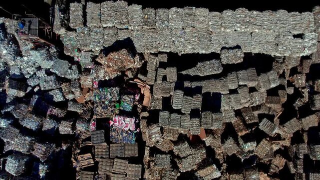 Drone aerial view of large paper rolls inside a paper manufacturing facility. The scene highlights industrial production, storage, logistics, and factory layout from an overhead perspective.