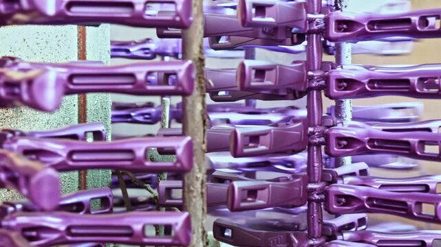 Close-up of pot handle components produced on an automated line inside a metal factory, showing precision manufacturing, durable materials, and industrial production process for cookware parts