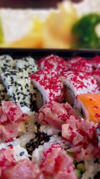 Philadelphia rolls, close-up sushi. Vertical video. Salmon sushi, assorted rice rolls. Ginger and chopsticks.