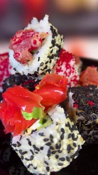 Philadelphia rolls, close-up sushi. Vertical video. Salmon sushi, assorted rice rolls. Ginger and chopsticks.