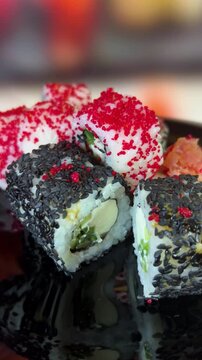 Philadelphia rolls, close-up sushi. Vertical video. Salmon sushi, assorted rice rolls. Ginger and chopsticks.