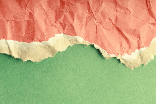 torn crumpled paper on top against a background of solid green paper. paper textured surface in different colors