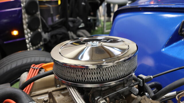 Close-up of a classic chrome carburetor air cleaner on a vintage engine