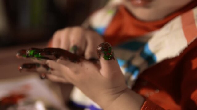 young child is playing with paint