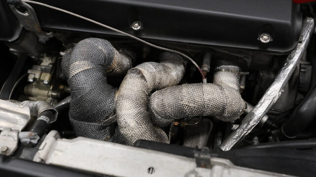 Close-up of engine exhaust headers with beige heat wrap