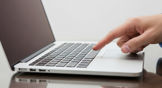 A person typing on a sleek laptop keyboard with a trackpad in use