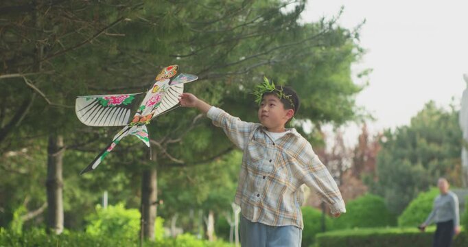 A Chinese mother and child play outdoors wearing willow leaf-woven clothes.