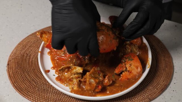 Showing a giant cooked mud crab claw covered in spicy chili sauce