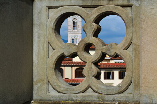View of Giotto's Campanile, the bell tower of the Cathedral of Santa Maria del Fiore, through the decorative stone opening of the balustrade on the upper floor of the Uffizi Gallery, Florence, Italy