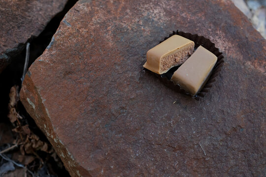 Masala praline of golden dune color on a desert bark color stone, and morning haze colors palette. Minimal. Moodboard. Copy space. Soft depth of field.