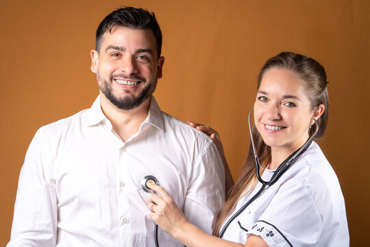 Doctora examinando la frecuencia card&iacute;aca de un paciente relajado y sonriente. Concepto de prevenci&oacute;n y asistencia m&eacute;dica