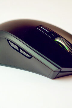 A close-up image of a computer mouse sitting on a clean and white surface, great for tech-related concepts or minimalistic designs. vertical frame