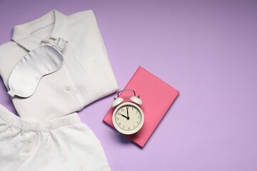 Alarm clock, pajamas, sleep mask and book on violet background, flat lay. Space for text