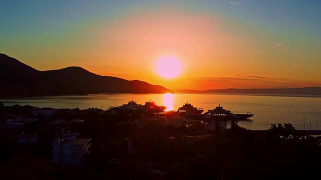  Ferry port in Thasos Greece at sunset with golden sea reflection aerial reveal