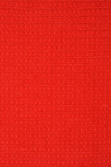 Fototapeta premium A close up shot of a vibrant red cotton fabric featuring a classic waffle weave pattern with a textured surface 