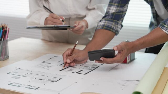 Architects, designers, structural engineers, and their team and colleagues are working on building plans and the design of a real estate construction project.