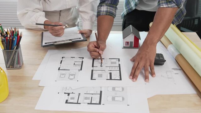 Architects, designers, structural engineers, and their team and colleagues are working on building plans and the design of a real estate construction project.