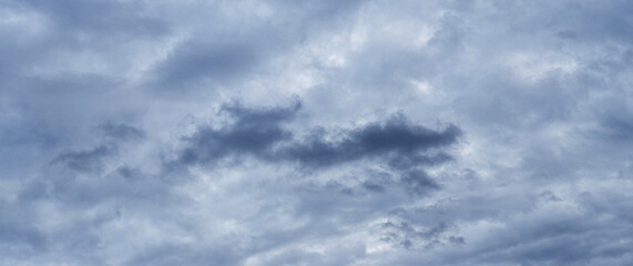 Fototapeta premium Uniformly overcast grey-blue sky with layered clouds, panoramic view, natural lighting