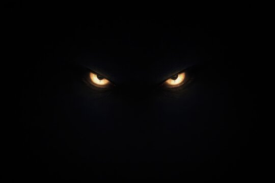Glowing monster eyes shining in the complete pitch black darkness.
