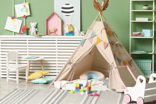 Cute wigwam and toys in stylish child's room