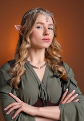 Fototapeta premium Portrait of beautiful elf girl on brown gradient background