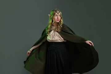 Fototapeta premium Beautiful girl dressed as elf on grey background