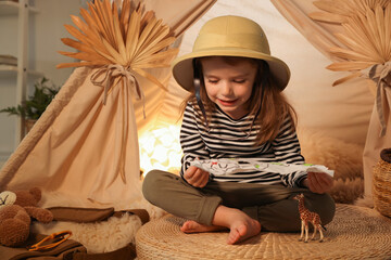 Little girl with drawing of map near wigwam at home. Space for text © New Africa