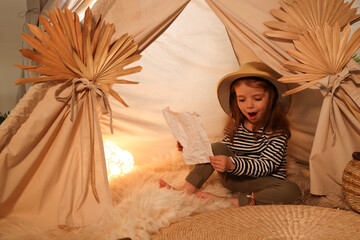 Little girl with drawing of map near wigwam at home. Space for text © New Africa