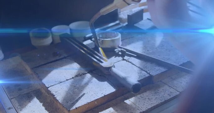 Torch entering from right, jeweler heating bench-clamped metal, melting solder and joining pieces