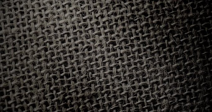 Diagonal Pan Over Woven Texture. Smooth slow diagonal movement across extreme close-up of coarse woven fabric with visible threads and dramatic side lighting.