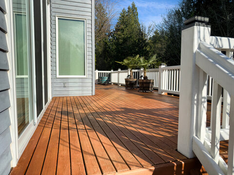 Home exterior with cedar wood deck that was freshly stained during spring season before summer use