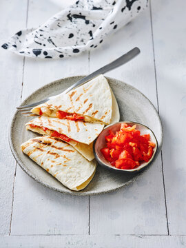 The image shows grilled tortillas filled with a fresh tomato salsa served on a rustic plate. This setup is perfect for menus, food blogs, and casual dining advertisements